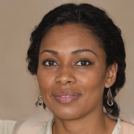 Joyful black adult female with medium  brown hair and brown eyes
