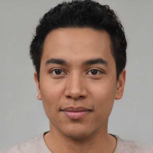 Joyful latino young-adult male with short  black hair and brown eyes