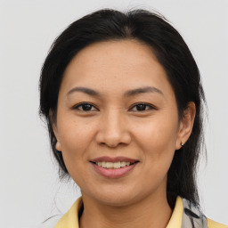 Joyful asian adult female with medium  brown hair and brown eyes