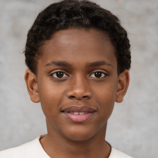 Joyful black child male with short  brown hair and brown eyes