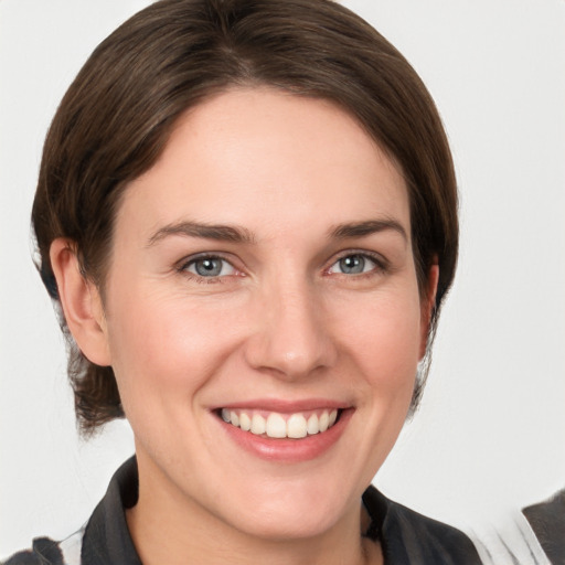 Joyful white young-adult female with medium  brown hair and grey eyes