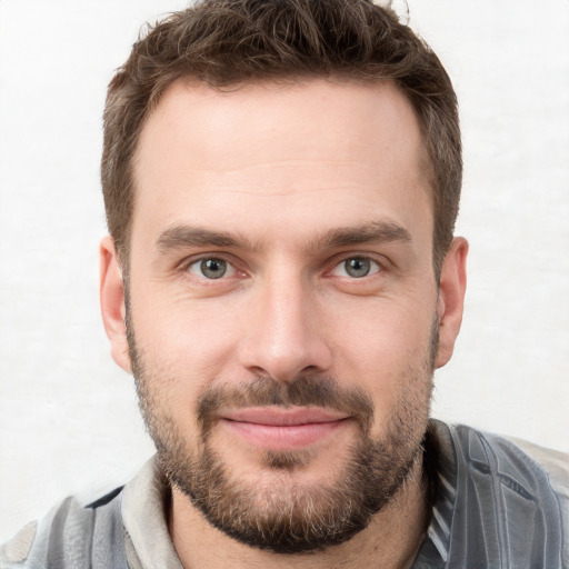 Joyful white young-adult male with short  brown hair and grey eyes