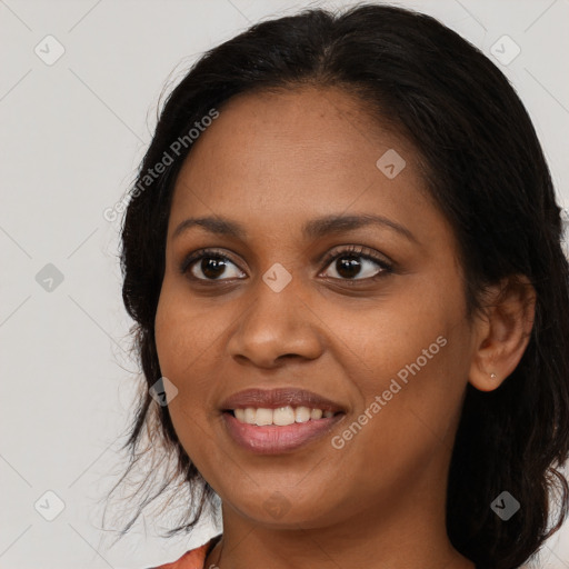 Joyful black young-adult female with long  brown hair and brown eyes