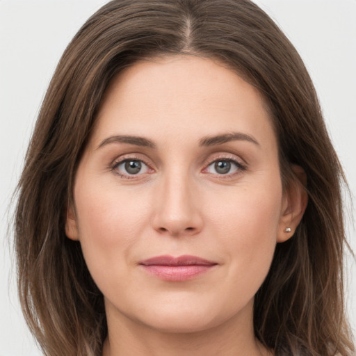 Joyful white young-adult female with long  brown hair and grey eyes