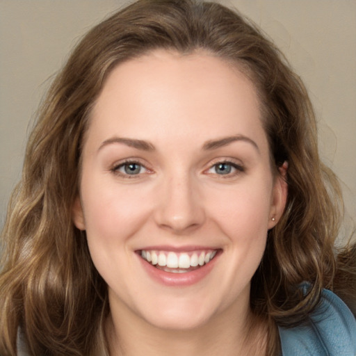 Joyful white young-adult female with long  brown hair and grey eyes