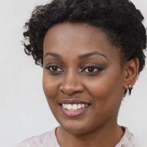 Joyful black young-adult female with short  brown hair and brown eyes