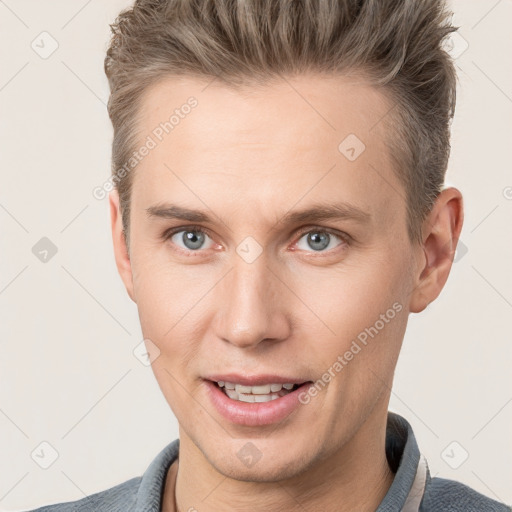 Joyful white young-adult male with short  brown hair and grey eyes