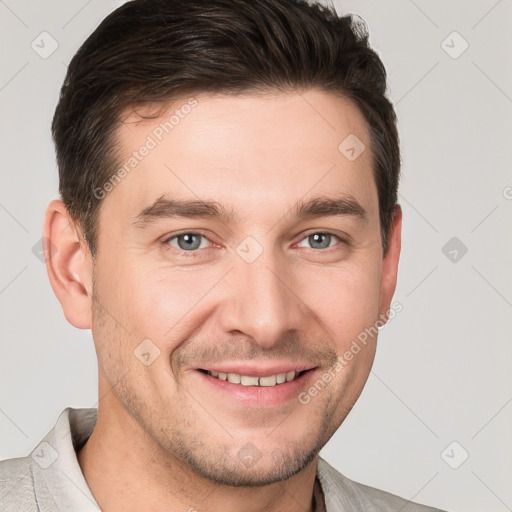 Joyful white young-adult male with short  brown hair and grey eyes