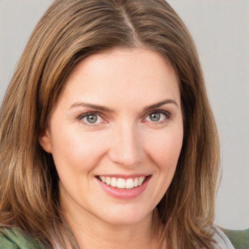 Joyful white young-adult female with medium  brown hair and green eyes