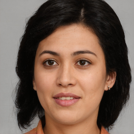 Joyful latino young-adult female with medium  brown hair and brown eyes