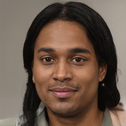 Joyful black young-adult male with medium  black hair and brown eyes