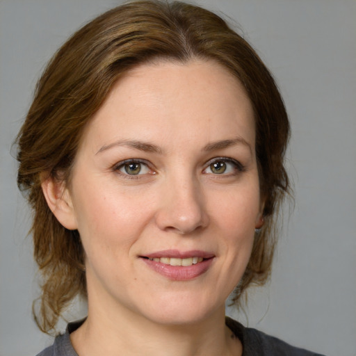 Joyful white adult female with medium  brown hair and grey eyes