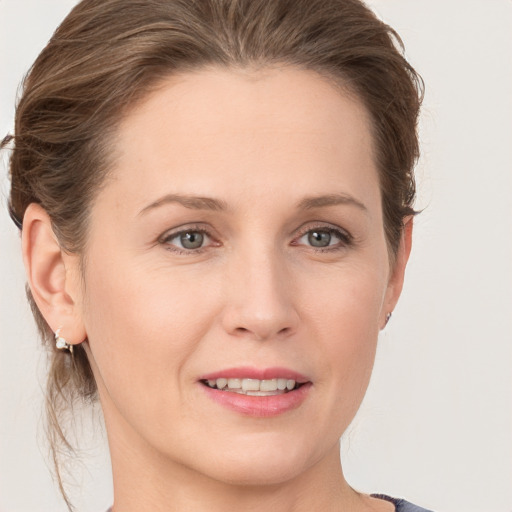 Joyful white young-adult female with medium  brown hair and grey eyes