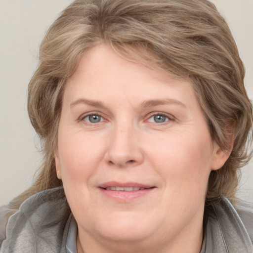 Joyful white adult female with medium  brown hair and grey eyes