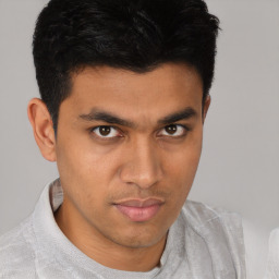 Joyful latino young-adult male with short  brown hair and brown eyes