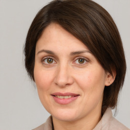 Joyful white adult female with medium  brown hair and green eyes