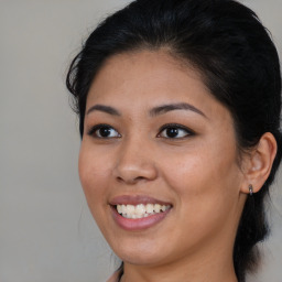 Joyful latino young-adult female with medium  brown hair and brown eyes