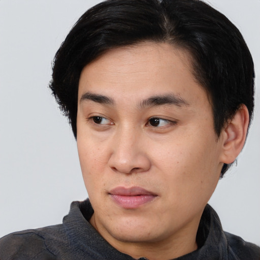 Joyful asian young-adult male with short  black hair and brown eyes