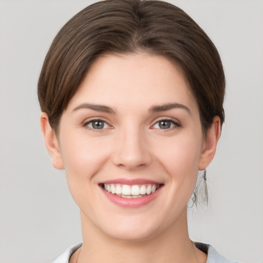 Joyful white young-adult female with short  brown hair and grey eyes