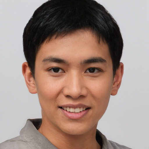 Joyful asian young-adult male with short  brown hair and brown eyes