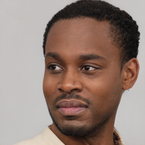 Joyful black young-adult male with short  black hair and brown eyes
