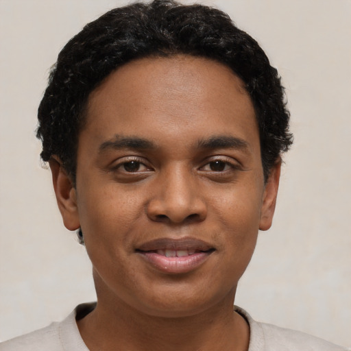 Joyful black young-adult male with short  black hair and brown eyes