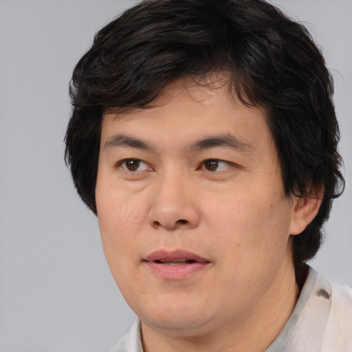 Joyful asian adult male with short  brown hair and brown eyes