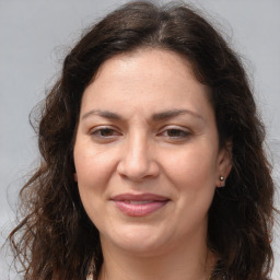 Joyful white adult female with long  brown hair and brown eyes