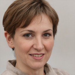 Joyful white adult female with short  brown hair and grey eyes