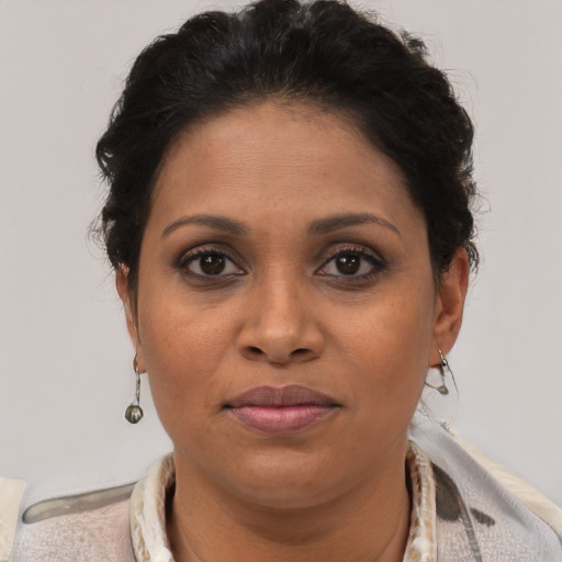 Joyful latino adult female with short  brown hair and brown eyes