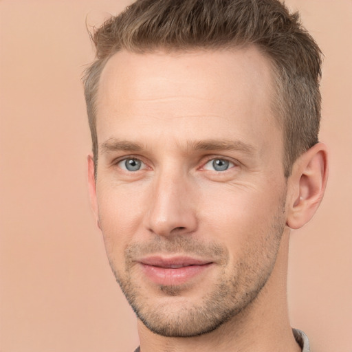 Joyful white young-adult male with short  brown hair and grey eyes