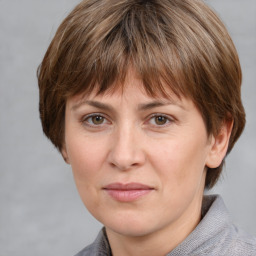 Joyful white adult female with medium  brown hair and grey eyes