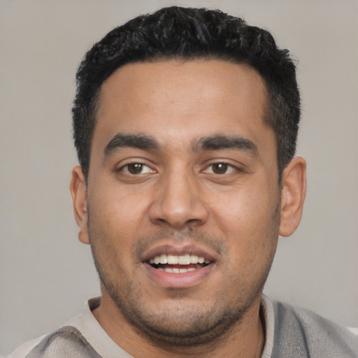 Joyful latino young-adult male with short  black hair and brown eyes