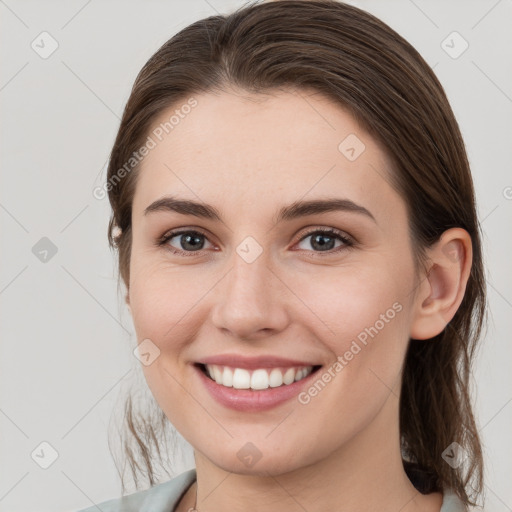 Joyful white young-adult female with medium  brown hair and grey eyes