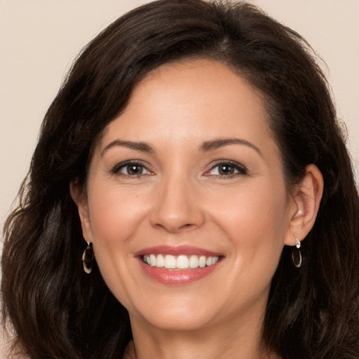 Joyful white adult female with long  brown hair and brown eyes