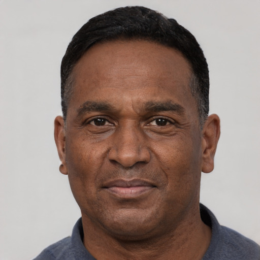 Joyful black adult male with short  black hair and brown eyes