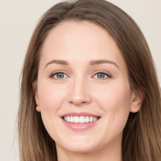 Joyful white young-adult female with long  brown hair and grey eyes