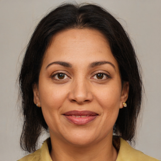 Joyful latino adult female with medium  brown hair and brown eyes