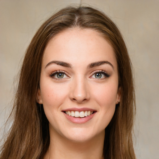 Joyful white young-adult female with long  brown hair and green eyes