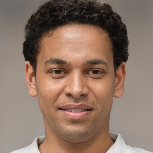 Joyful latino young-adult male with short  brown hair and brown eyes