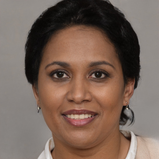 Joyful black adult female with short  brown hair and brown eyes