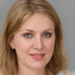 Joyful white young-adult female with long  brown hair and blue eyes