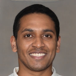 Joyful latino young-adult male with short  black hair and brown eyes