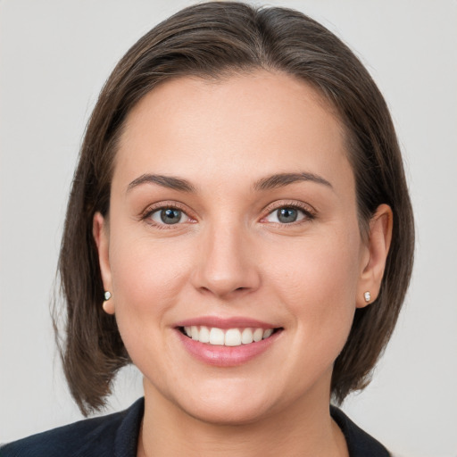 Joyful white young-adult female with medium  brown hair and grey eyes