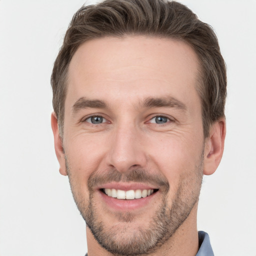 Joyful white young-adult male with short  brown hair and grey eyes