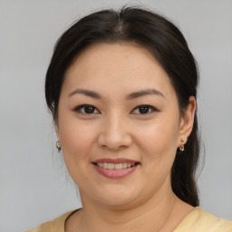 Joyful asian young-adult female with medium  brown hair and brown eyes