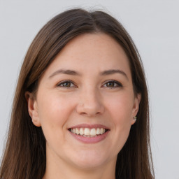 Joyful white young-adult female with long  brown hair and grey eyes