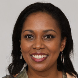 Joyful black adult female with long  brown hair and brown eyes