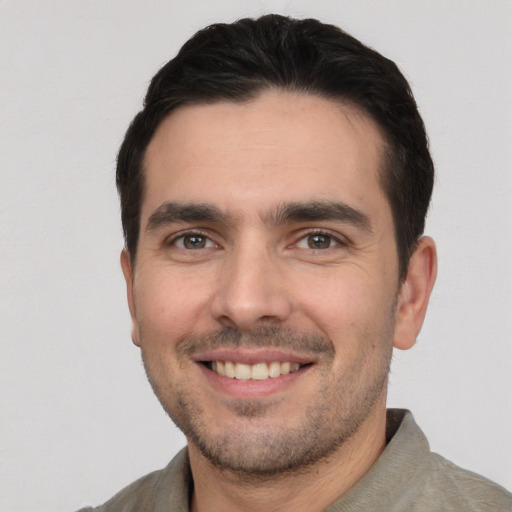 Joyful white young-adult male with short  black hair and brown eyes