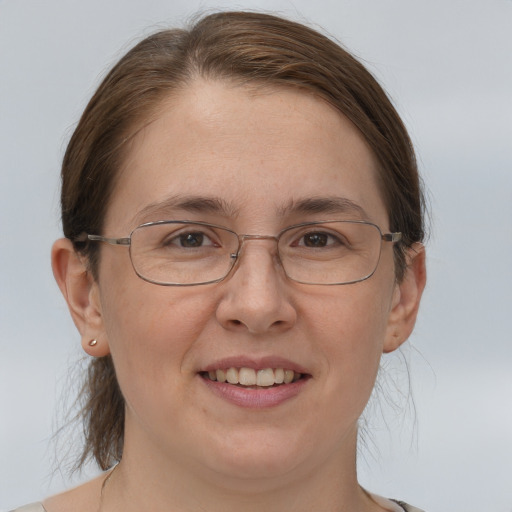 Joyful white adult female with medium  brown hair and grey eyes